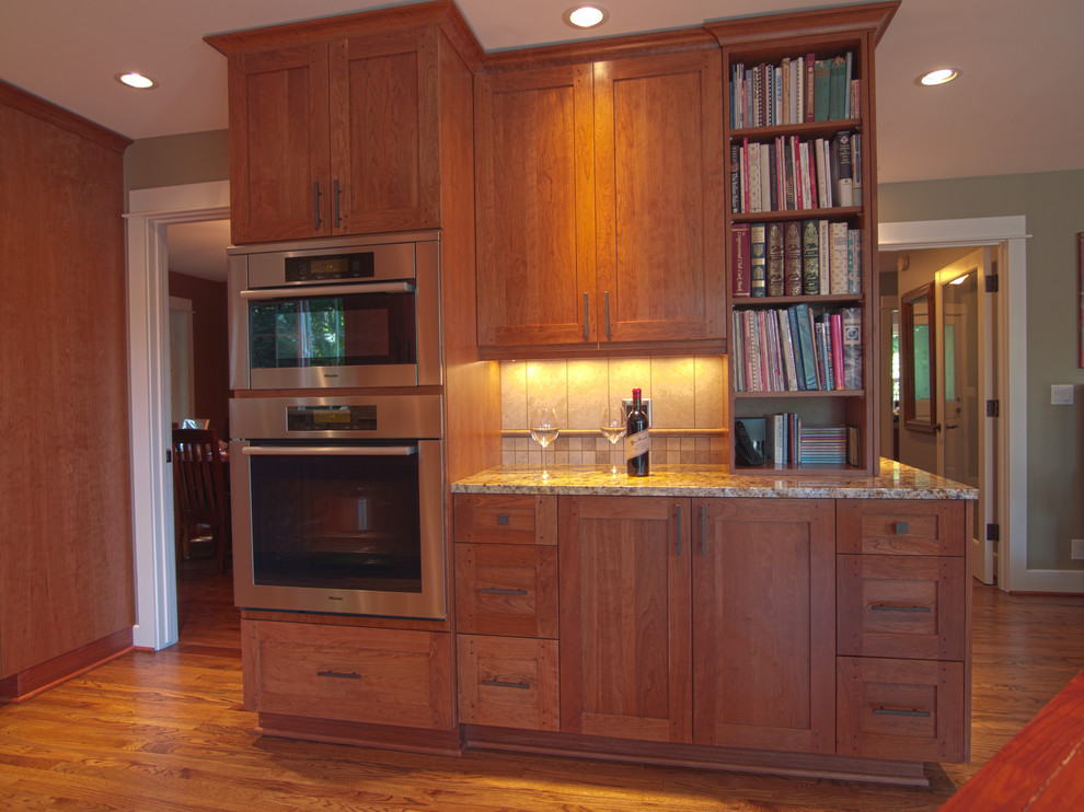 Example of a mid-sized transitional u-shaped medium tone wood floor and beige floor eat-in kitchen design in Seattle with an undermount sink, recessed-panel cabinets, medium tone wood cabinets, granite countertops, beige backsplash, stone tile backsplash, stainless steel appliances, no island and beige countertops