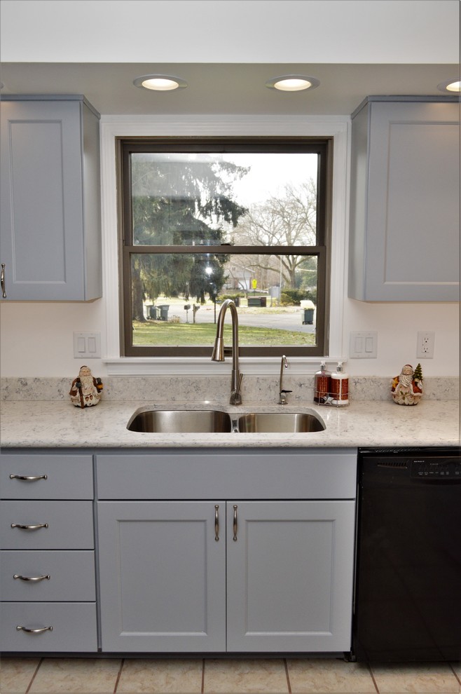 Inredning av ett klassiskt mellanstort grå grått kök, med en undermonterad diskho, skåp i shakerstil, blå skåp, bänkskiva i kvartsit och en halv köksö