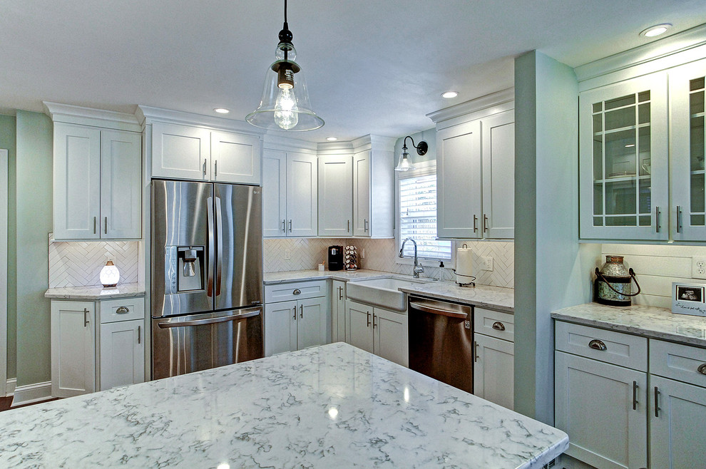 Bild på ett mellanstort lantligt vit vitt kök, med en undermonterad diskho, skåp i shakerstil, vita skåp, bänkskiva i kvarts, vitt stänkskydd, stänkskydd i keramik, rostfria vitvaror, mellanmörkt trägolv, en halv köksö och brunt golv