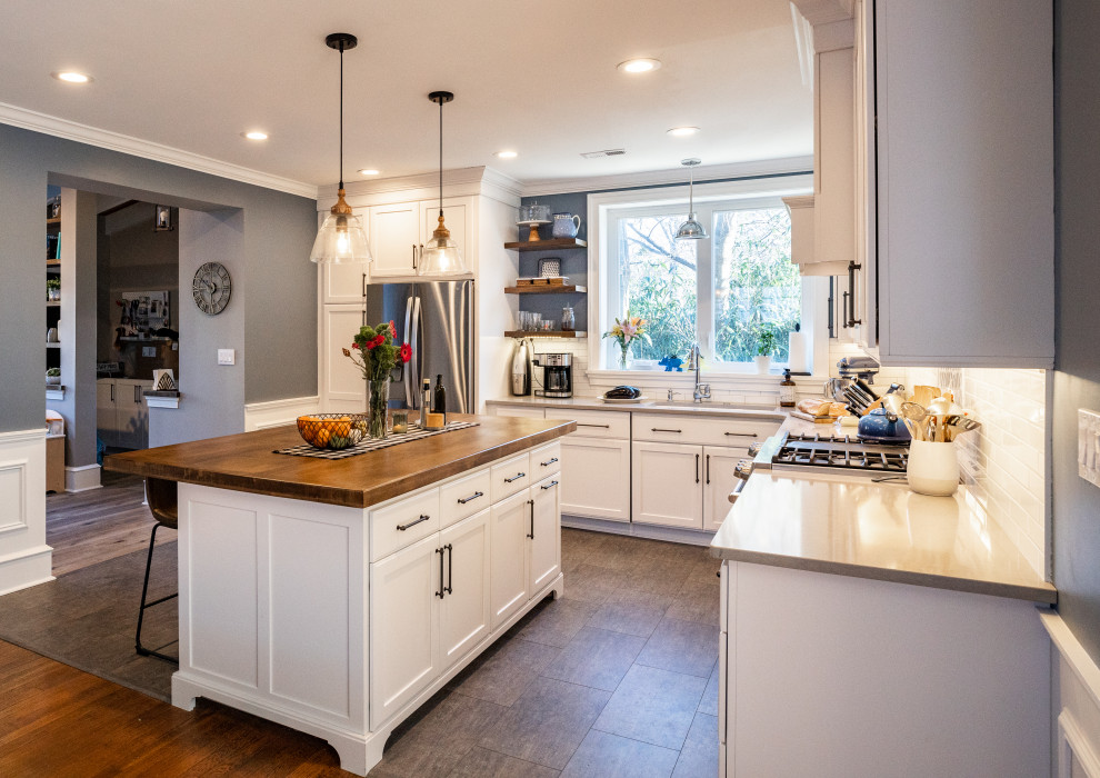 Design ideas for a medium sized rural l-shaped kitchen/diner in Philadelphia with a single-bowl sink, shaker cabinets, engineered stone countertops, white splashback, ceramic splashback, stainless steel appliances, laminate floors, an island, grey floors and beige worktops.