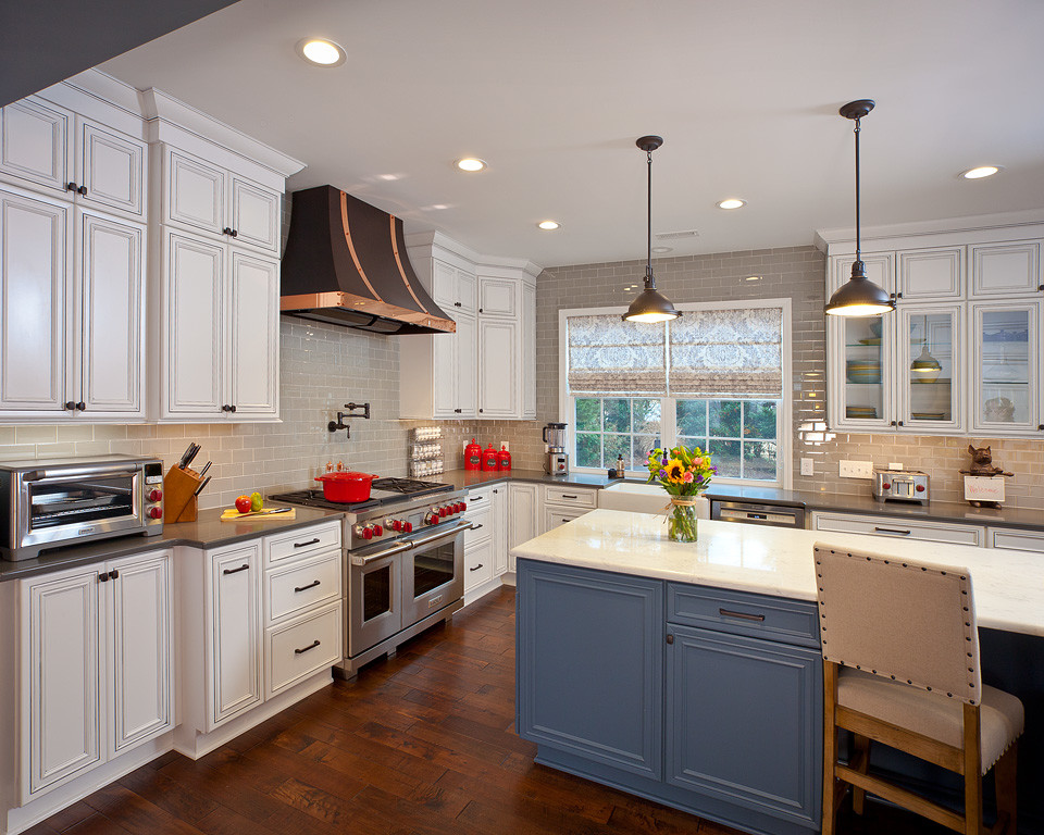 Enclosed kitchen - huge traditional l-shaped dark wood floor and brown floor enclosed kitchen idea in Raleigh with a farmhouse sink, recessed-panel cabinets, white cabinets, solid surface countertops, gray backsplash, subway tile backsplash, paneled appliances, an island and gray countertops
