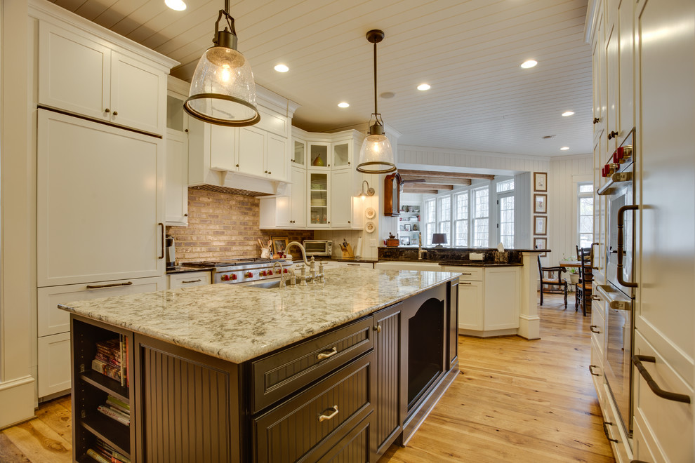 Große Country Küche in U-Form mit Landhausspüle, Granit-Arbeitsplatte, Küchengeräten aus Edelstahl, braunem Holzboden und Kücheninsel in Washington, D.C.