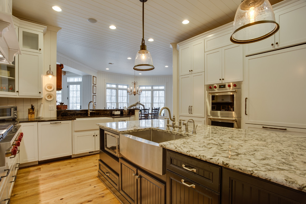 Große Landhaus Küche in U-Form mit Landhausspüle, Granit-Arbeitsplatte, Küchengeräten aus Edelstahl, braunem Holzboden und Kücheninsel in Washington, D.C.