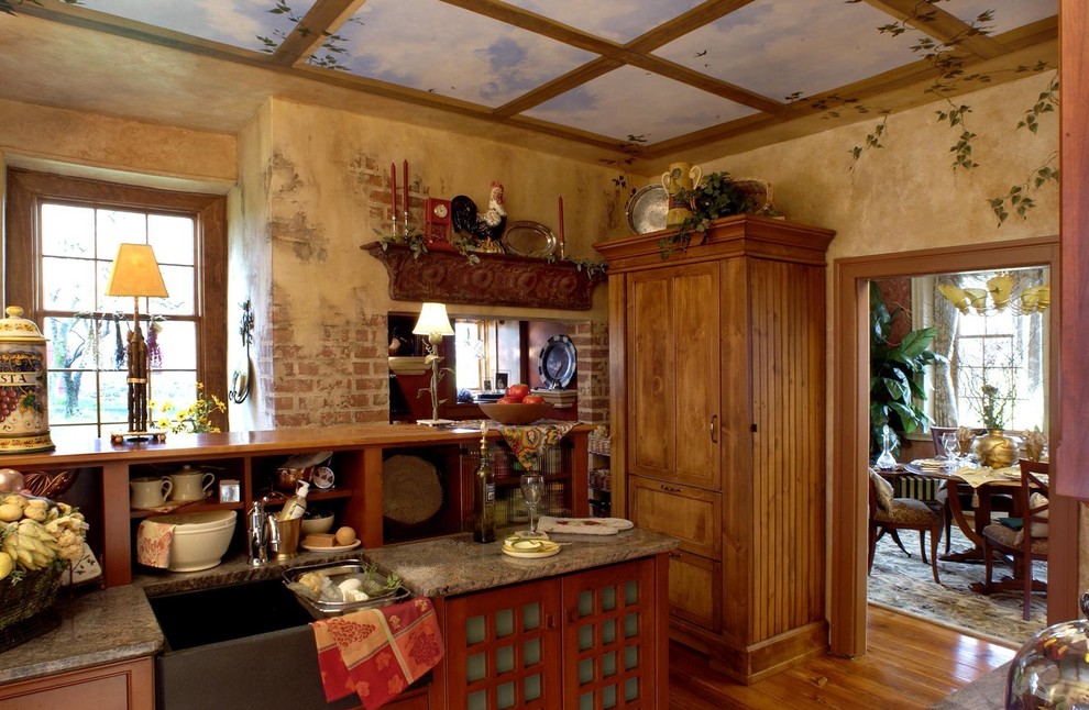 Immagine di una cucina rustica con lavello stile country, ante in legno scuro, top in granito e elettrodomestici da incasso