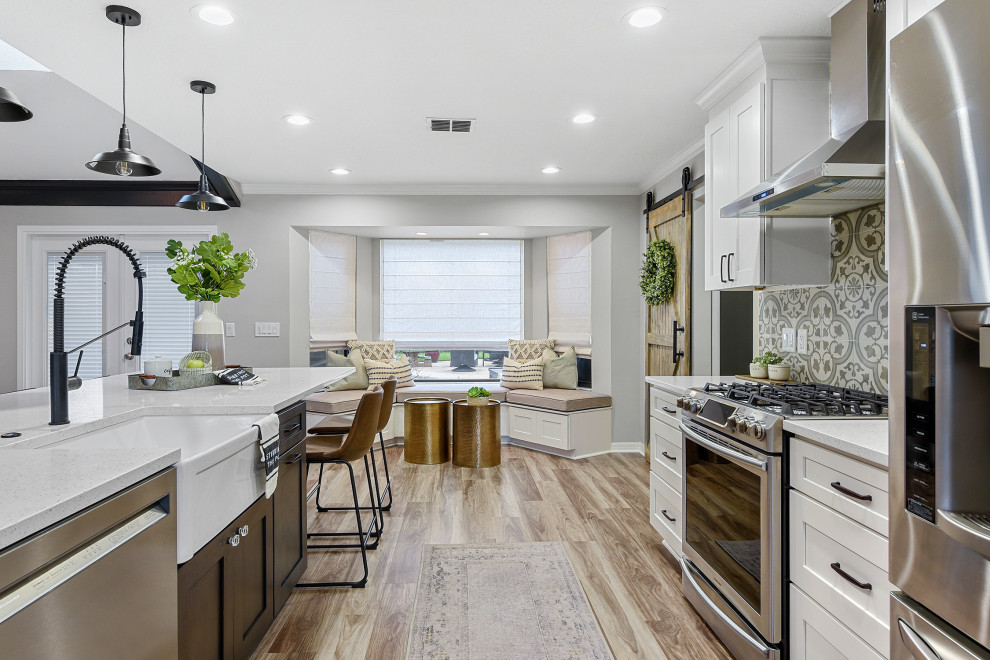 This is an example of a large country kitchen in Jacksonville with a belfast sink, shaker cabinets, engineered stone countertops, stainless steel appliances, an island and white worktops.
