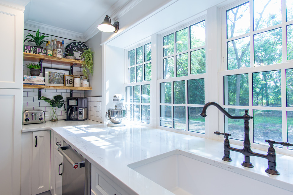 Example of a large farmhouse eat-in kitchen design in Philadelphia with shaker cabinets, white cabinets, quartz countertops, white backsplash, subway tile backsplash, stainless steel appliances, an island and white countertops