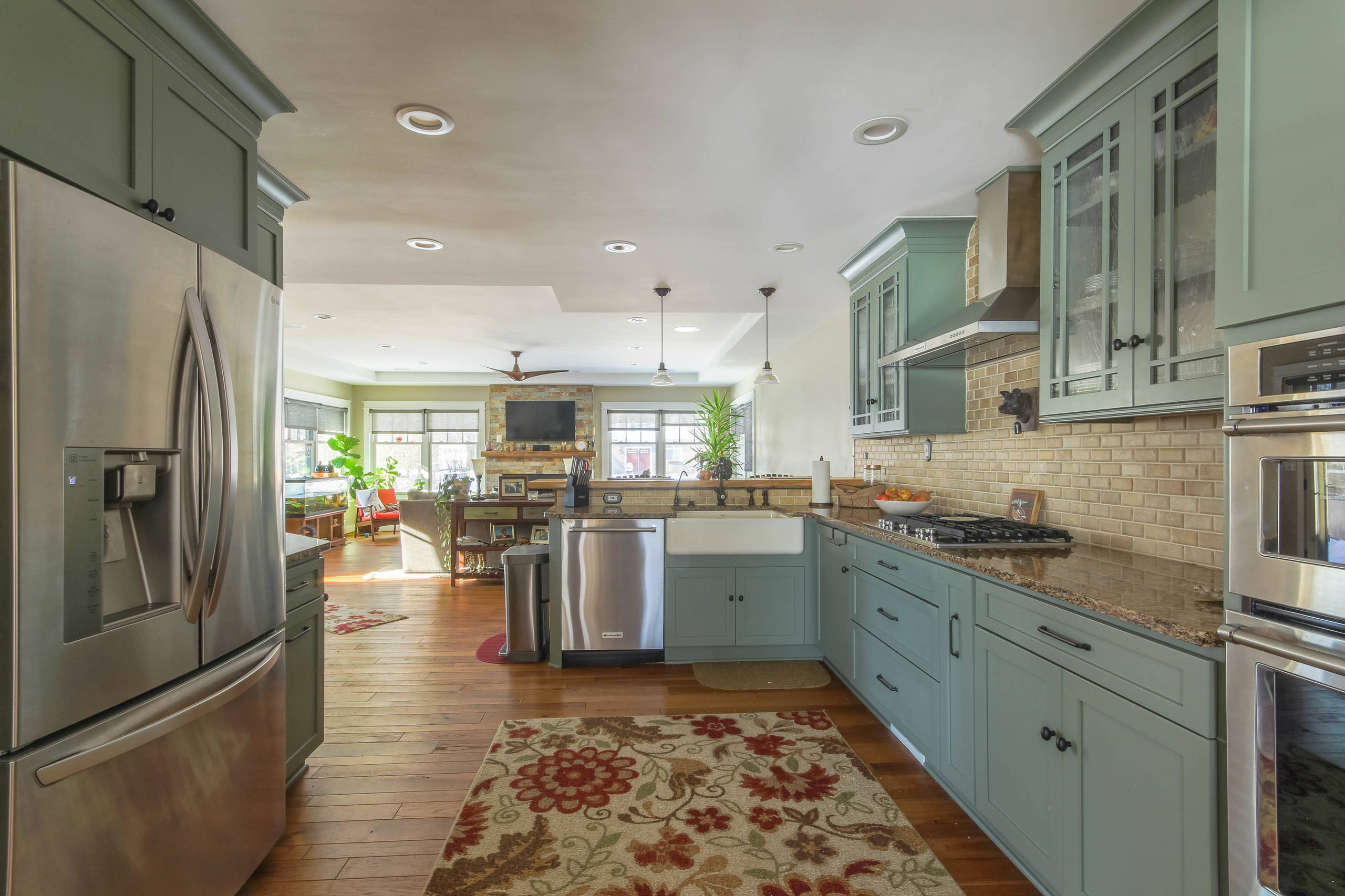 Sage green kitchen cabinets with tan granite countertops in a small  contemporary style kitchen on Craiyon