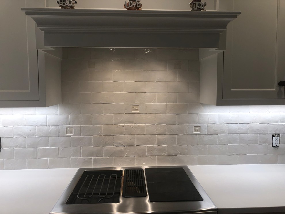 This is an example of a medium sized rural u-shaped enclosed kitchen in Portland with a double-bowl sink, recessed-panel cabinets, white cabinets, concrete worktops, white splashback, ceramic splashback, stainless steel appliances, an island and white worktops.