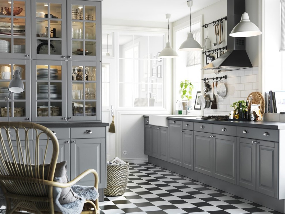 Inspiration for a mid-sized country kitchen pantry remodel in Other with a farmhouse sink, glass-front cabinets, gray cabinets, beige backsplash, ceramic backsplash and an island