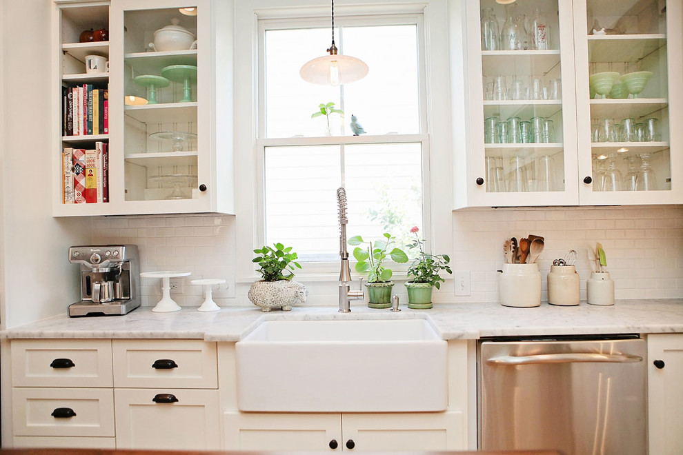 Example of a mid-sized country galley kitchen pantry design in Other with a farmhouse sink, glass-front cabinets, beige backsplash, ceramic backsplash and an island