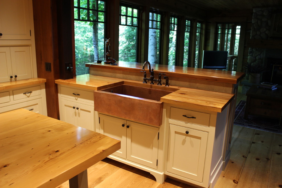 Idéer för mellanstora lantliga kök, med en rustik diskho, luckor med profilerade fronter, vita skåp, träbänkskiva, beige stänkskydd, stänkskydd i keramik, mellanmörkt trägolv och en köksö