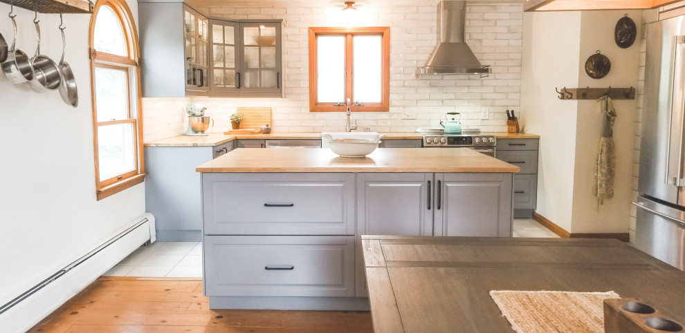 Idéer för att renovera ett lantligt kök och matrum, med en rustik diskho, grå skåp, träbänkskiva, vitt stänkskydd, stänkskydd i tunnelbanekakel, rostfria vitvaror och en köksö