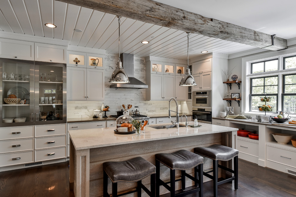 This is an example of a rural l-shaped kitchen in Chicago with a submerged sink, shaker cabinets, white cabinets, white splashback, metro tiled splashback, stainless steel appliances, dark hardwood flooring and an island.