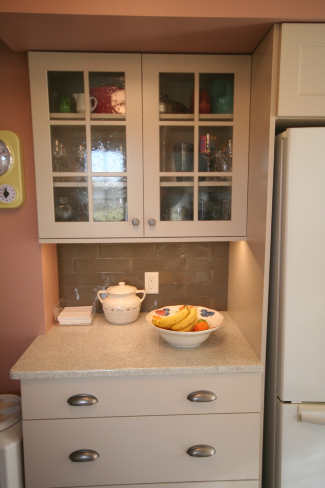This is an example of a medium sized country galley enclosed kitchen in Detroit with a belfast sink, shaker cabinets, beige cabinets, granite worktops, ceramic splashback, laminate floors, grey splashback and white appliances.