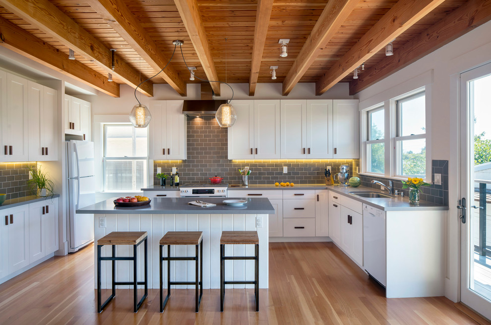 Inspiration for a cottage u-shaped medium tone wood floor kitchen remodel in San Francisco with shaker cabinets, gray backsplash, ceramic backsplash, white appliances, an island, an undermount sink and white cabinets