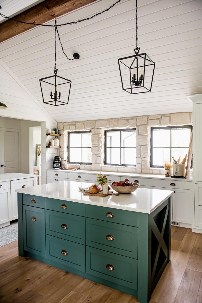 Inspiration for a farmhouse l-shaped kitchen in San Diego with shaker cabinets, white cabinets, medium hardwood flooring, an island, brown floors and white worktops.