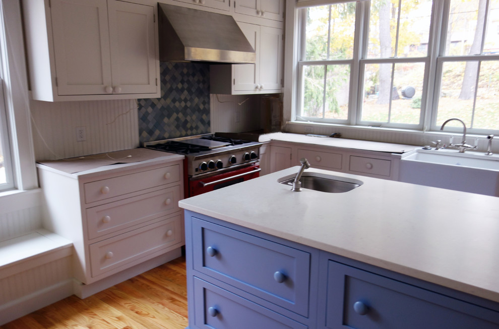 Idéer för att renovera ett avskilt, mellanstort lantligt l-kök, med en rustik diskho, skåp i shakerstil, blå skåp, bänkskiva i kvartsit, blått stänkskydd, stänkskydd i keramik, rostfria vitvaror, mellanmörkt trägolv och en köksö