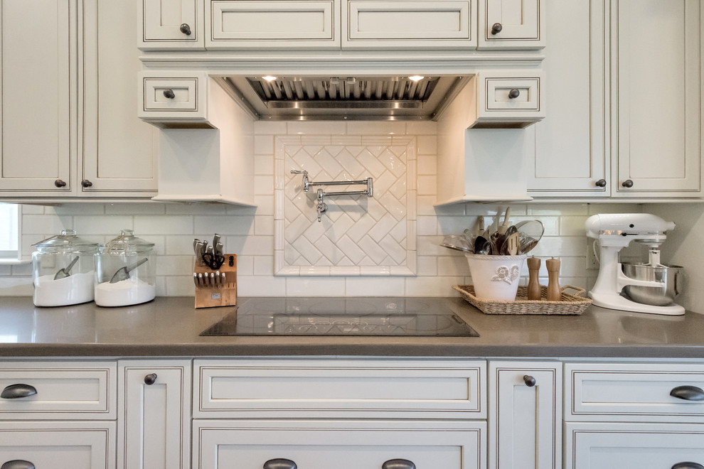 Inspiration for a large cottage l-shaped porcelain tile and gray floor open concept kitchen remodel in Phoenix with a farmhouse sink, raised-panel cabinets, white cabinets, granite countertops, white backsplash, subway tile backsplash, stainless steel appliances and an island