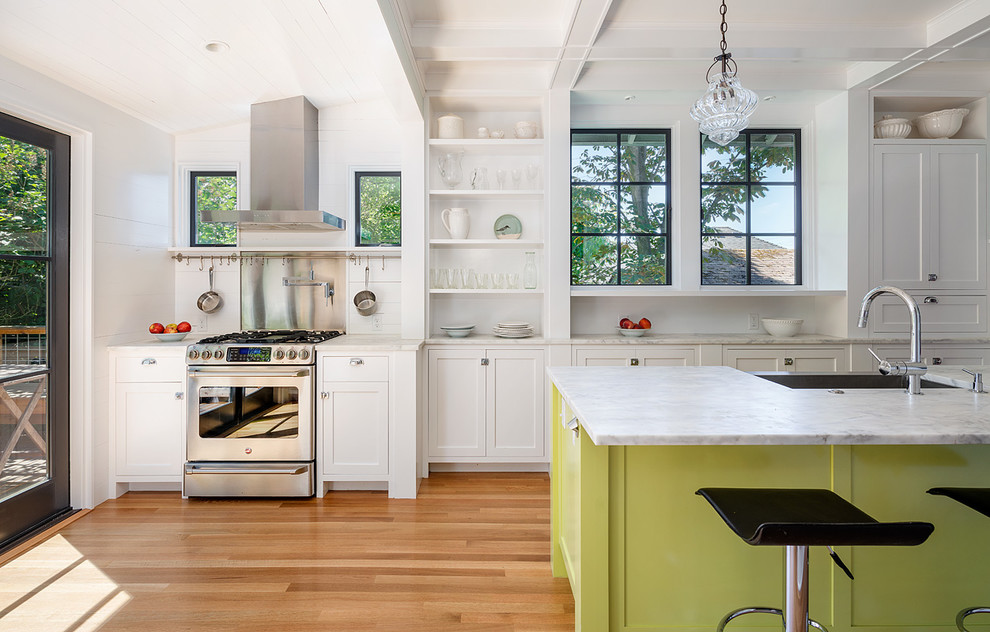 Landhaus Küche mit Schrankfronten im Shaker-Stil, weißen Schränken, hellem Holzboden und Kücheninsel in Seattle