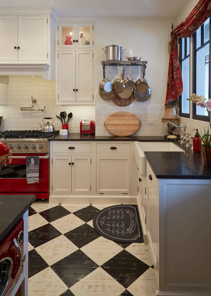 Kitchen - country l-shaped painted wood floor and multicolored floor kitchen idea in Chicago with a farmhouse sink, shaker cabinets, white cabinets, white backsplash, subway tile backsplash, colored appliances and an island