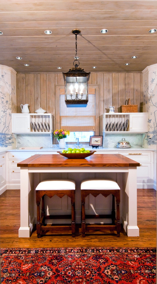 Photo of a farmhouse kitchen in Charlotte with shaker cabinets, white cabinets, medium hardwood flooring and an island.