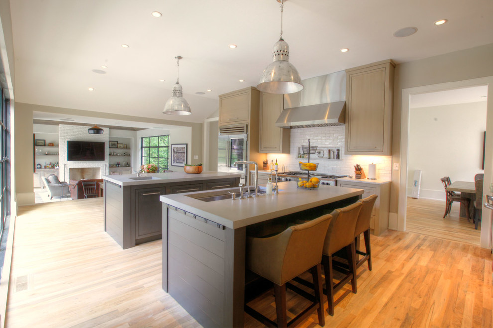 Foto de cocina contemporánea abierta con puertas de armario grises, salpicadero blanco, salpicadero de azulejos tipo metro y electrodomésticos de acero inoxidable
