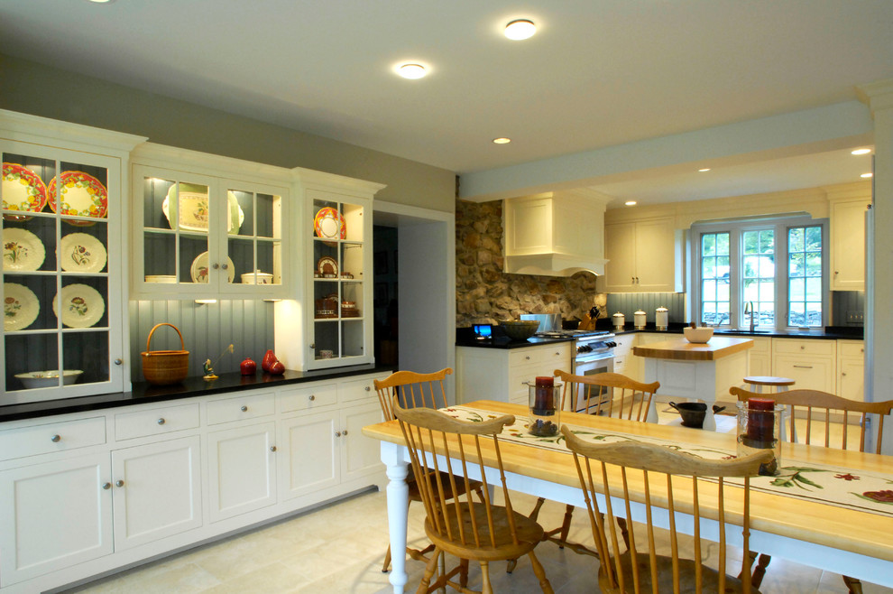 Exempel på ett mellanstort lantligt kök, med en undermonterad diskho, luckor med profilerade fronter, vita skåp, granitbänkskiva, blått stänkskydd, integrerade vitvaror och travertin golv