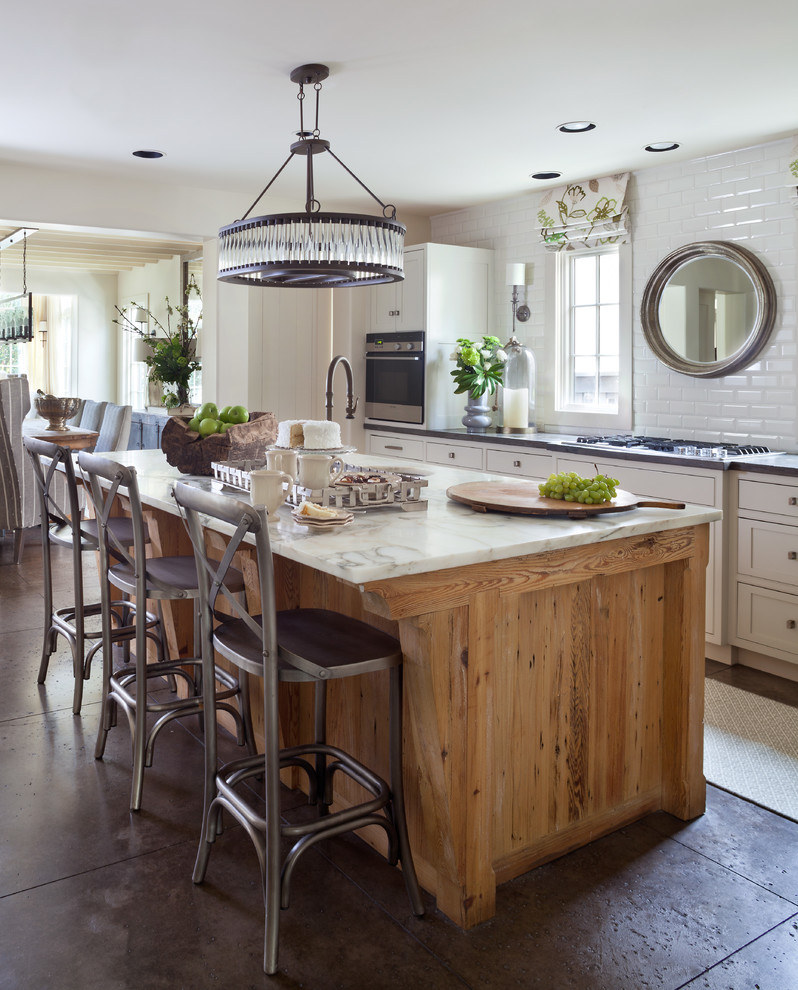 Example of a farmhouse kitchen design in Denver with an undermount sink, recessed-panel cabinets, beige cabinets, white backsplash, subway tile backsplash and an island