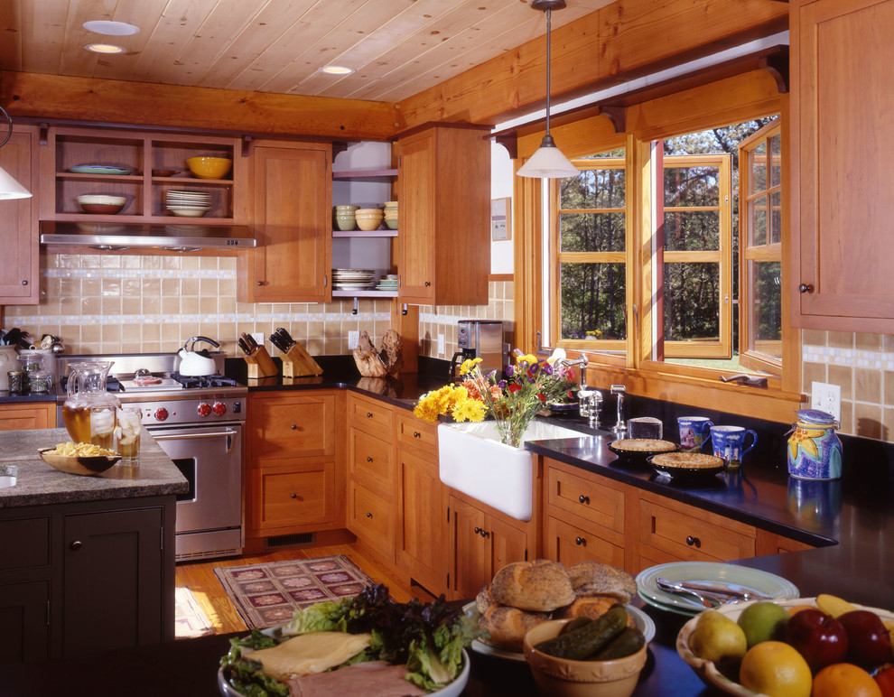 Foto på ett u-kök, med en rustik diskho, släta luckor, skåp i mellenmörkt trä, granitbänkskiva, rostfria vitvaror, mellanmörkt trägolv och en köksö
