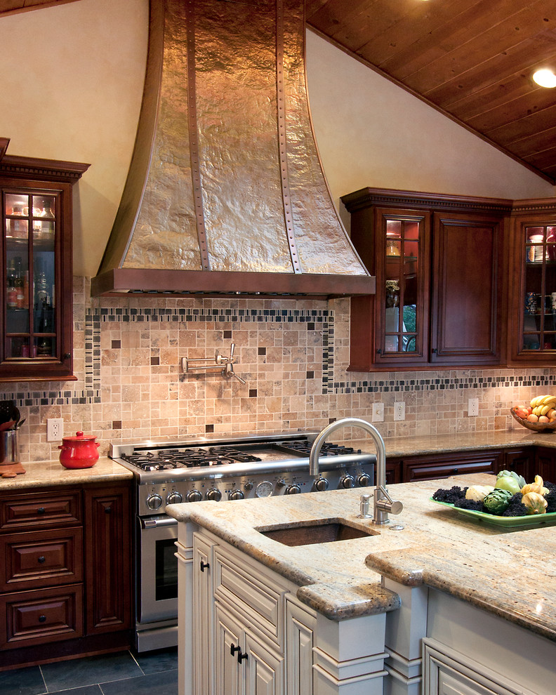 Bild på ett stort vintage kök, med en rustik diskho, luckor med upphöjd panel, skåp i mörkt trä, granitbänkskiva, flerfärgad stänkskydd, stänkskydd i stenkakel, rostfria vitvaror, travertin golv, en köksö och svart golv