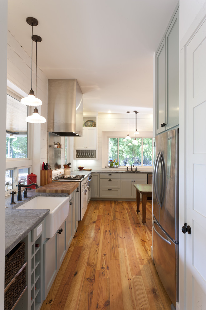 Design ideas for a farmhouse kitchen in Austin with stainless steel appliances, a belfast sink and soapstone worktops.