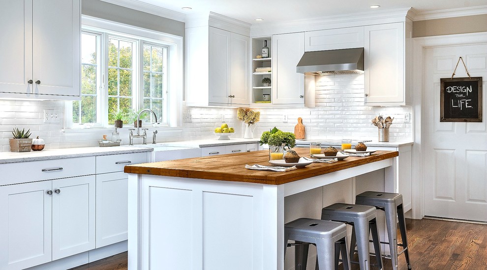 Inspiration for a medium sized classic grey and cream l-shaped enclosed kitchen in Other with a belfast sink, white cabinets, engineered stone countertops, white splashback, ceramic splashback, medium hardwood flooring, an island, shaker cabinets, stainless steel appliances and brown floors.