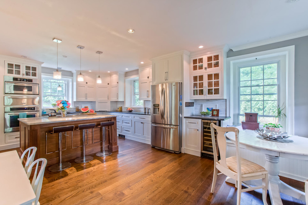 Moderne Wohnküche in L-Form mit Schrankfronten im Shaker-Stil, weißen Schränken, Küchenrückwand in Weiß und Küchengeräten aus Edelstahl in Philadelphia