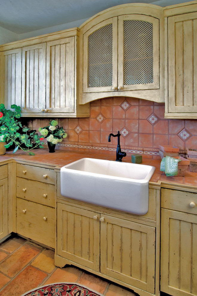 This is an example of a medium sized mediterranean u-shaped kitchen pantry in Albuquerque with a belfast sink, beaded cabinets, yellow cabinets, marble worktops, multi-coloured splashback, terracotta splashback and terracotta flooring.