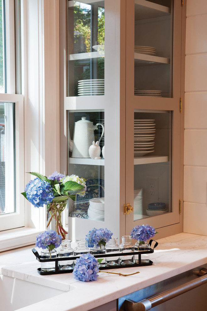 Example of a farmhouse u-shaped light wood floor kitchen design in Boston with flat-panel cabinets, gray cabinets, white backsplash, stainless steel appliances and an island