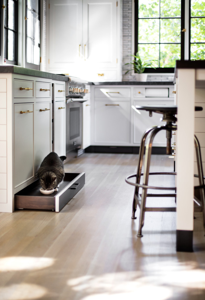 Lantlig inredning av ett mellanstort kök, med en undermonterad diskho, skåp i shakerstil, grå skåp, granitbänkskiva, grått stänkskydd, stänkskydd i mosaik, färgglada vitvaror, ljust trägolv, en köksö och brunt golv