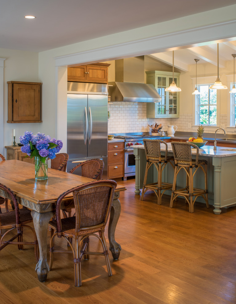 Bild på ett stort lantligt flerfärgad flerfärgat kök, med en undermonterad diskho, skåp i shakerstil, skåp i mellenmörkt trä, vitt stänkskydd, stänkskydd i tunnelbanekakel, rostfria vitvaror, mellanmörkt trägolv, en köksö och brunt golv