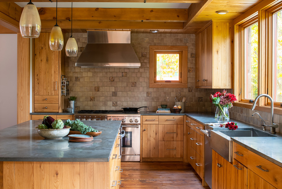 Exempel på ett lantligt grå grått l-kök, med en rustik diskho, släta luckor, skåp i mellenmörkt trä, bänkskiva i rostfritt stål, beige stänkskydd, rostfria vitvaror, mellanmörkt trägolv, en köksö och brunt golv