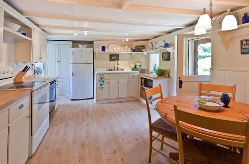 Farmhouse style kitchen with beadboard cabinets and open shelving