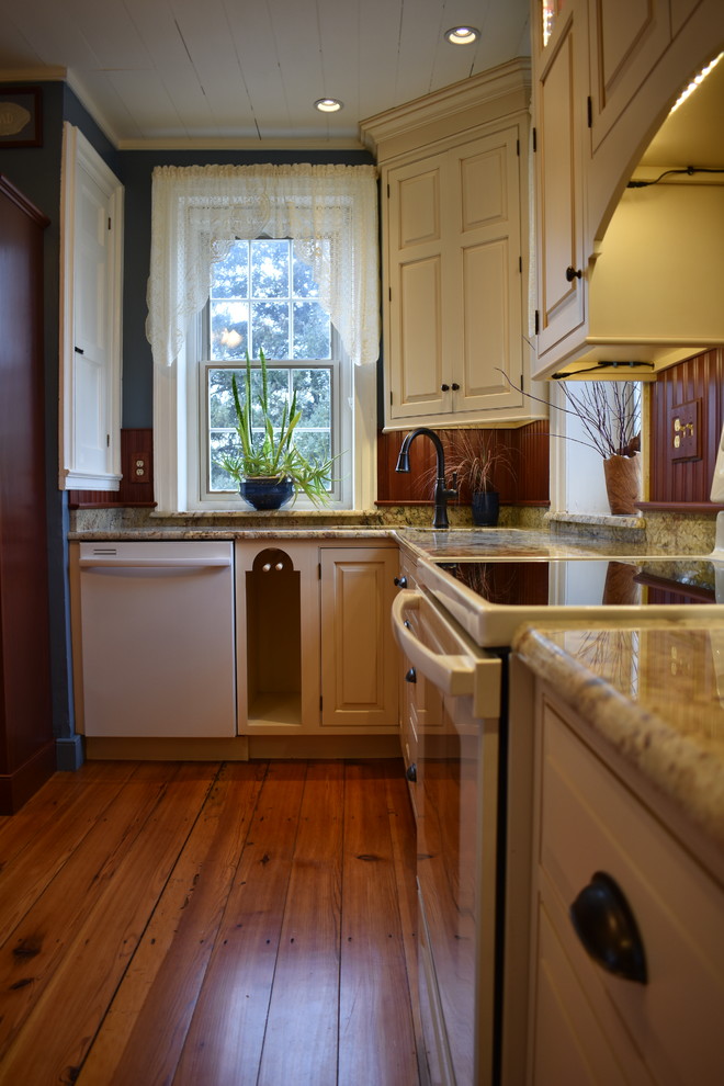 Eat-in kitchen - mid-sized cottage u-shaped light wood floor and brown floor eat-in kitchen idea in Other with an undermount sink, raised-panel cabinets, beige cabinets, granite countertops, brown backsplash, wood backsplash, white appliances, a peninsula and multicolored countertops