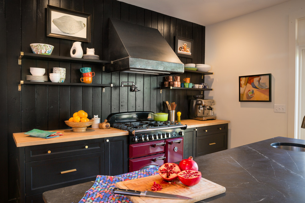 ボストンにある高級な広いモダンスタイルのおしゃれなキッチン (ドロップインシンク、オープンシェルフ、黒いキャビネット、大理石カウンター、黒いキッチンパネル、木材のキッチンパネル、黒い調理設備、無垢フローリング、茶色い床、黒いキッチンカウンター) の写真