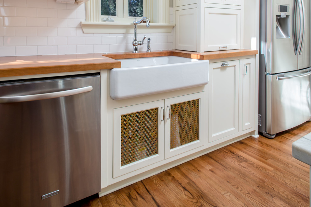 Exempel på ett stort klassiskt kök, med en rustik diskho, vita skåp, vitt stänkskydd, rostfria vitvaror, mellanmörkt trägolv, en köksö, skåp i shakerstil, träbänkskiva och stänkskydd i tunnelbanekakel