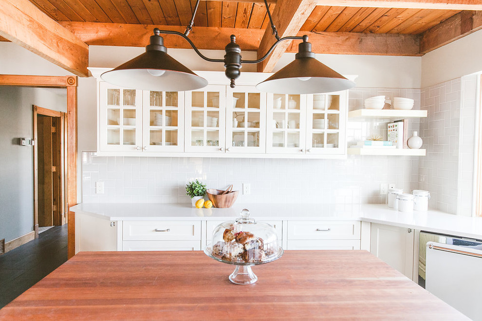 Eat-in kitchen - small cottage u-shaped ceramic tile eat-in kitchen idea in Calgary with a farmhouse sink, glass-front cabinets, white cabinets, quartz countertops, gray backsplash, subway tile backsplash, white appliances and an island
