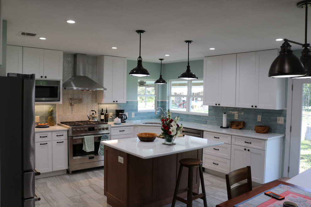 Bild på ett mellanstort lantligt vit vitt kök och matrum, med en rustik diskho, skåp i shakerstil, vita skåp, bänkskiva i kvarts, blått stänkskydd, stänkskydd i keramik, rostfria vitvaror, klinkergolv i keramik, en köksö och grått golv
