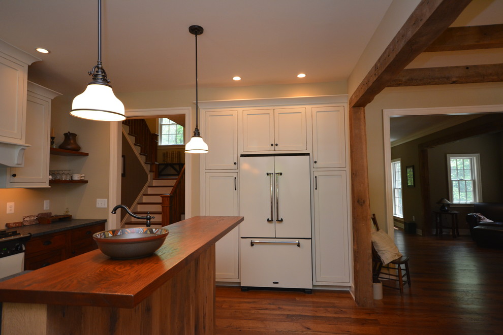 Large farmhouse galley medium tone wood floor eat-in kitchen photo in DC Metro with a farmhouse sink, recessed-panel cabinets, white cabinets, soapstone countertops, beige backsplash, stainless steel appliances and an island