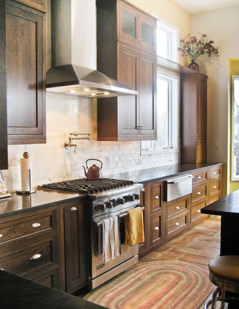 Mid-sized arts and crafts single-wall ceramic tile eat-in kitchen photo in Detroit with an undermount sink, flat-panel cabinets, dark wood cabinets, granite countertops, white backsplash, stone tile backsplash, stainless steel appliances and an island