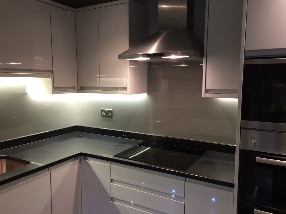 Mittelgroße Moderne Küche in L-Form mit Küchenrückwand in Grau und Rückwand aus Glasfliesen in Cheshire