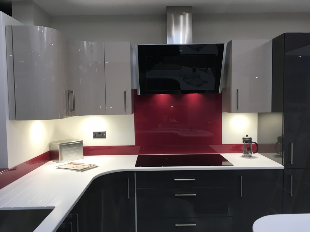 Modelo de cocina actual de tamaño medio con salpicadero rojo y salpicadero de vidrio templado