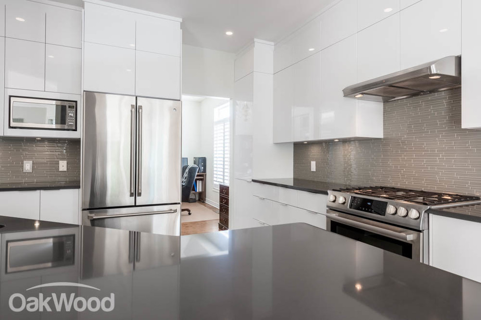 Enclosed kitchen - large contemporary l-shaped ceramic tile enclosed kitchen idea in Ottawa with an undermount sink, flat-panel cabinets, white cabinets, tile countertops, gray backsplash, glass tile backsplash, stainless steel appliances and a peninsula