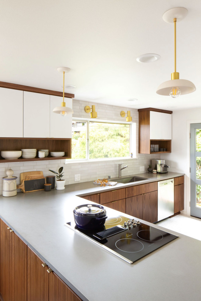 Cette image montre une cuisine vintage en L et bois brun de taille moyenne avec un évier encastré, un placard à porte plane, une crédence grise, une péninsule, un sol blanc, un plan de travail gris et fenêtre au-dessus de l'évier.